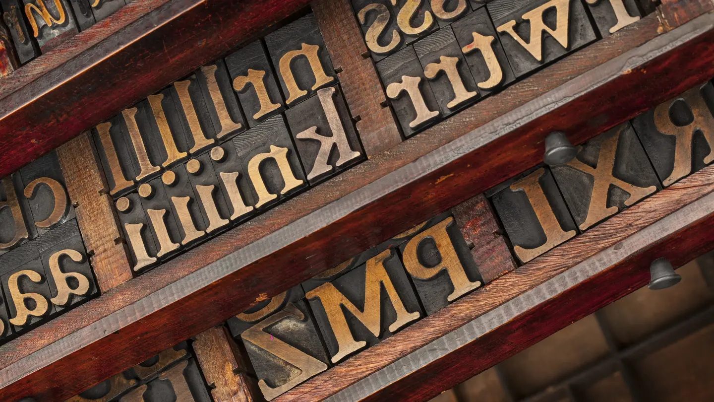 Drawers of vintage wooden letterpress type with serif letters, seen at an angle