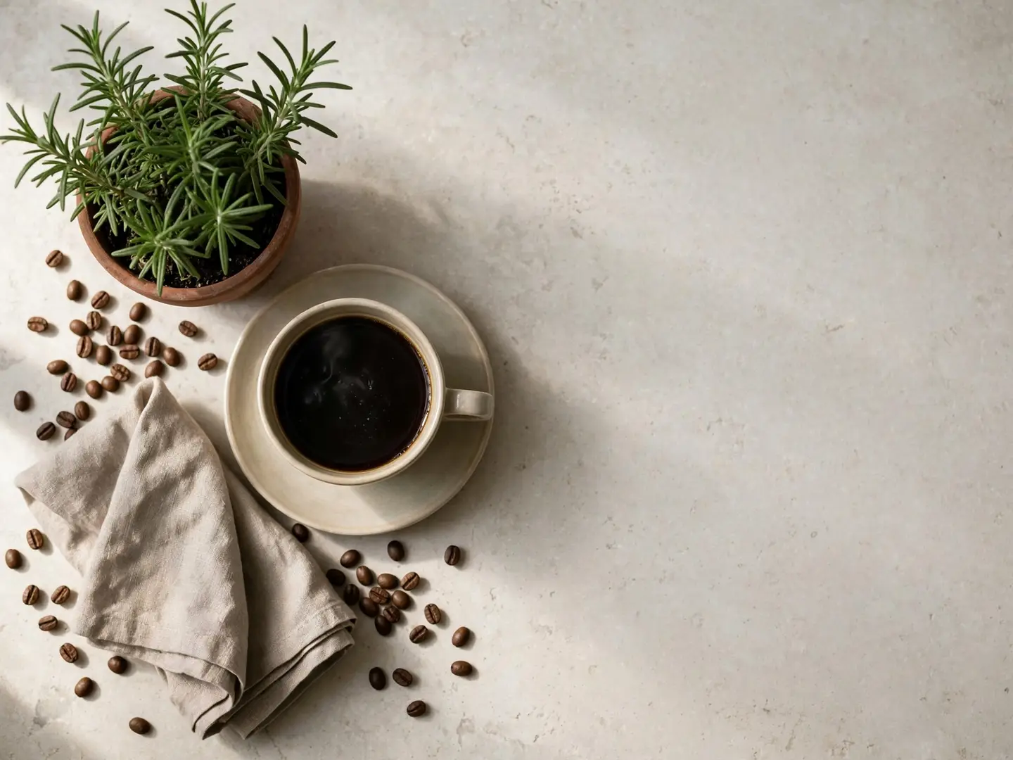 An AI-generated top-down flat lay of a cup of black coffee, a small terracotta pot of rosemary, a linen napkin and scattered coffee beans on a pale stone surface