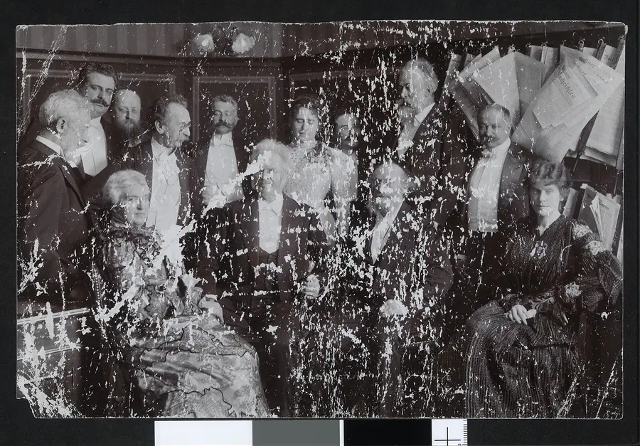 A formal group of men and women gathered in a room, the damaged original
