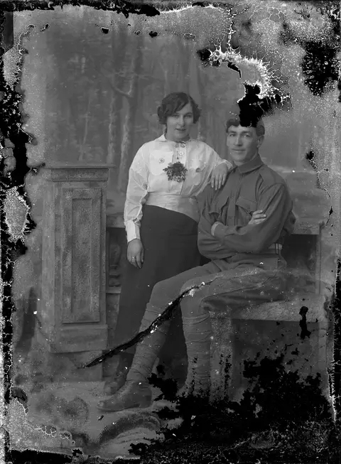 A soldier and a young woman on a stone bench: original