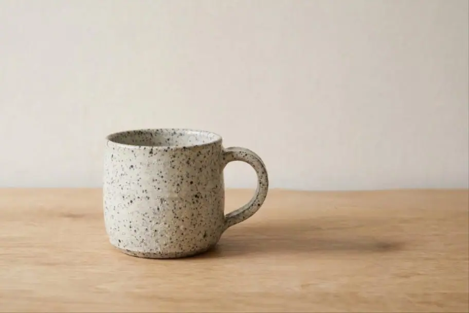 A ceramic mug on a wooden table, after editing