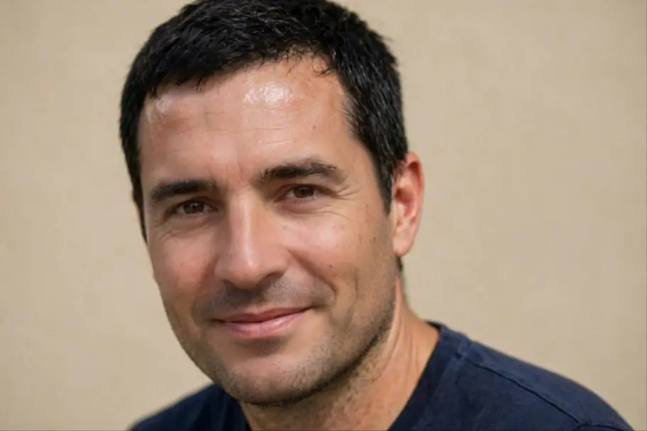 A close-up portrait of a man in natural light, after editing